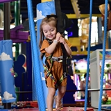 A girl goes on the indoor ropes course.