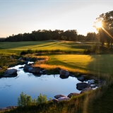 The sun rises above the golf course.