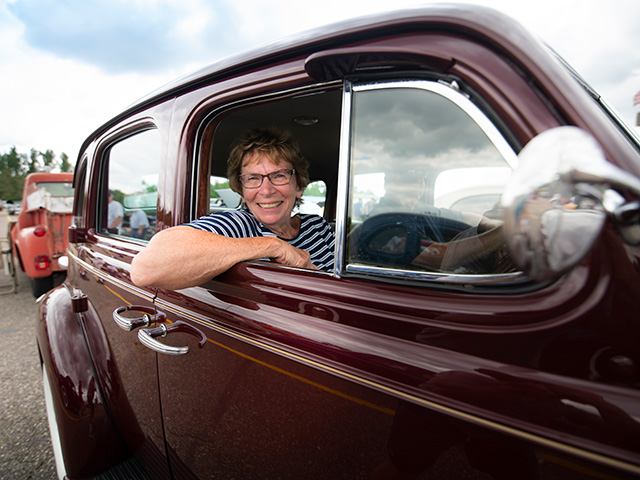 women in car at automotion classic car show