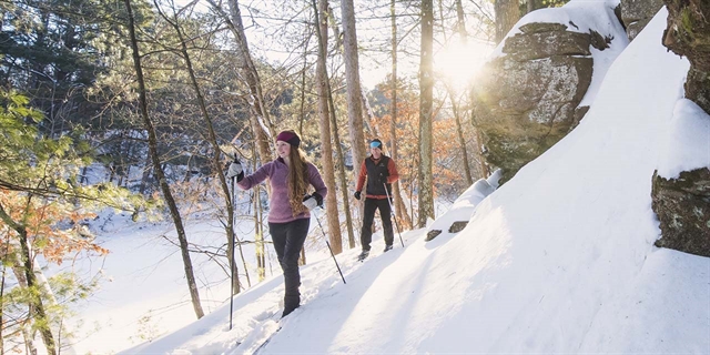A couple cross-country skiing at Mirror Lake State Park in Wisconsin Dells.