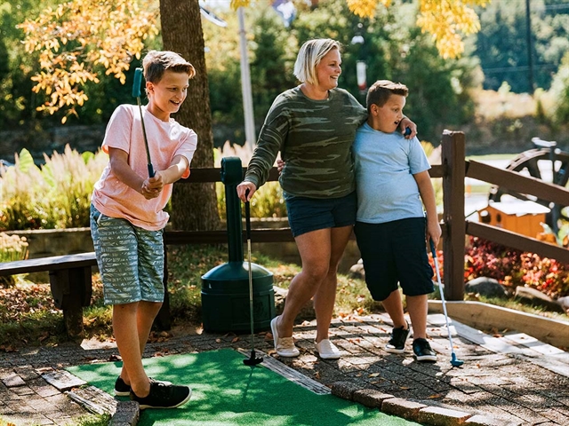 A family playing mini golf at Pirate's Cove Adventure Golf in Wisconsin Dells.
