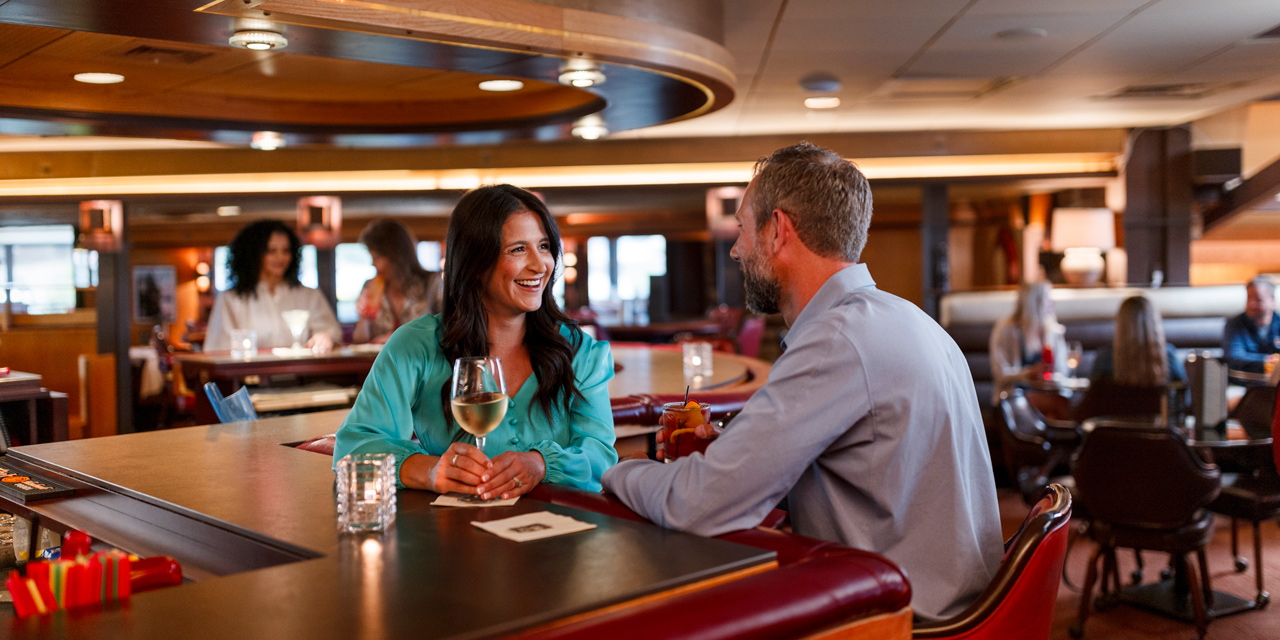 Couple sitting in front of the fireplace at Double Cut Charcoal Grill and Liquor Bar