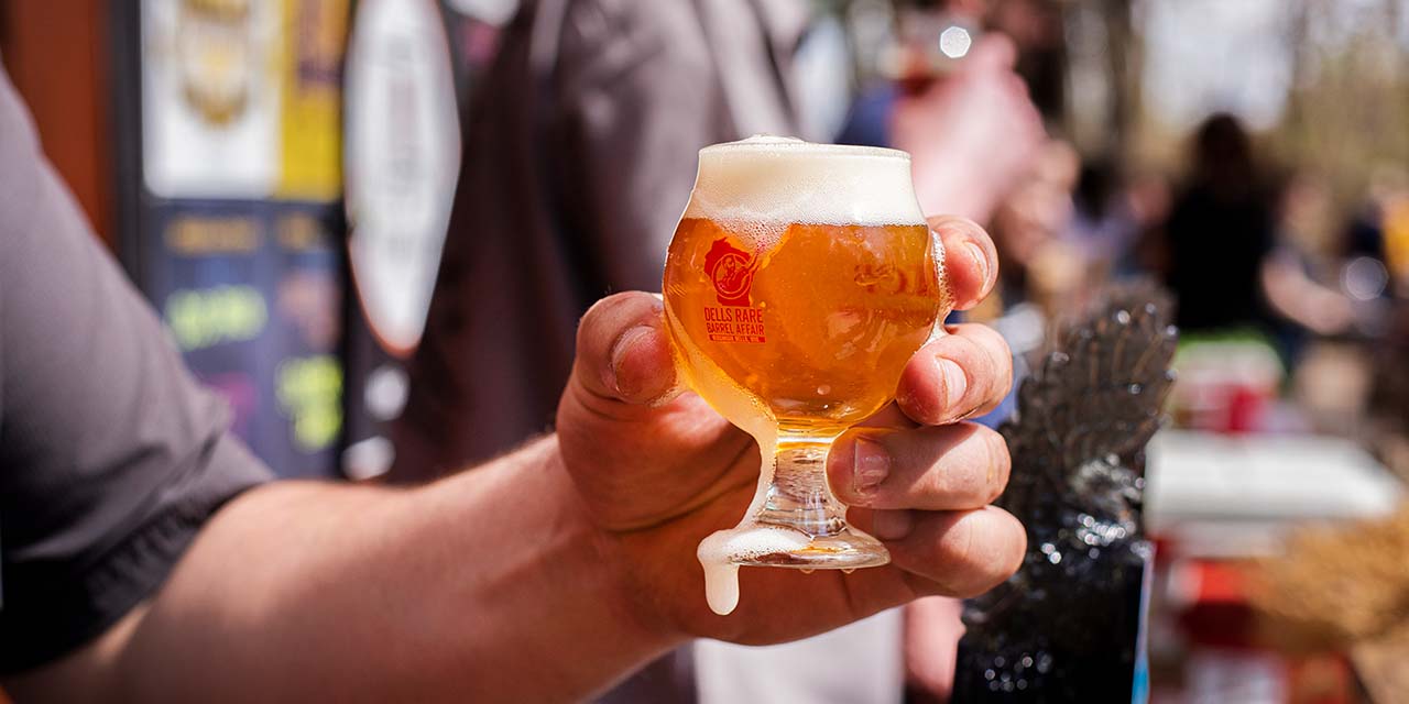 Man holding a Dells Rare Barrel Affair beer glass