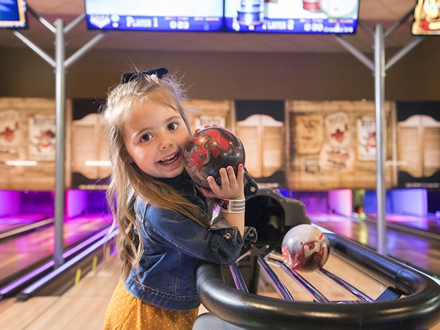 A girl bowling at Tom Foolerys Adventure Park in Wisconsin Dells.