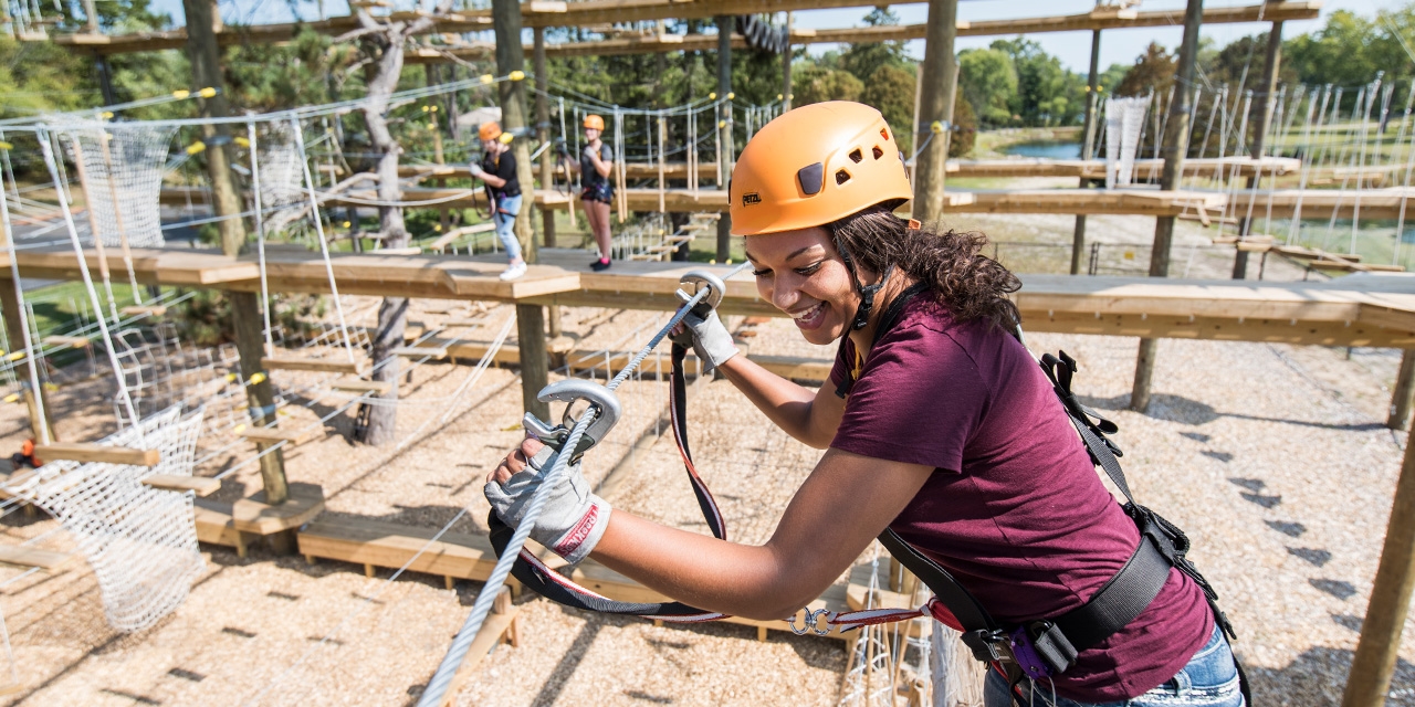 Young women climbing at Bigfoot ropes course