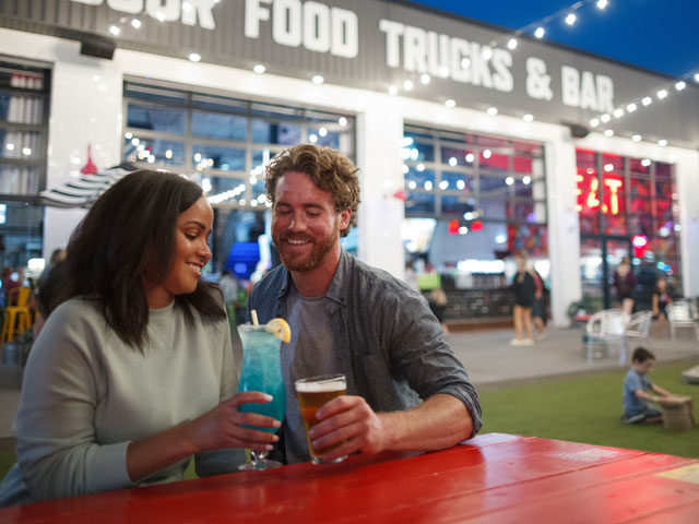 A couple enjoys drinks at an outdoor table at Grateful Shed