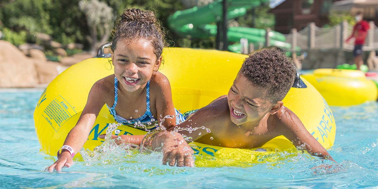 Two kids playing at Wilderness Waterpark floating tube.