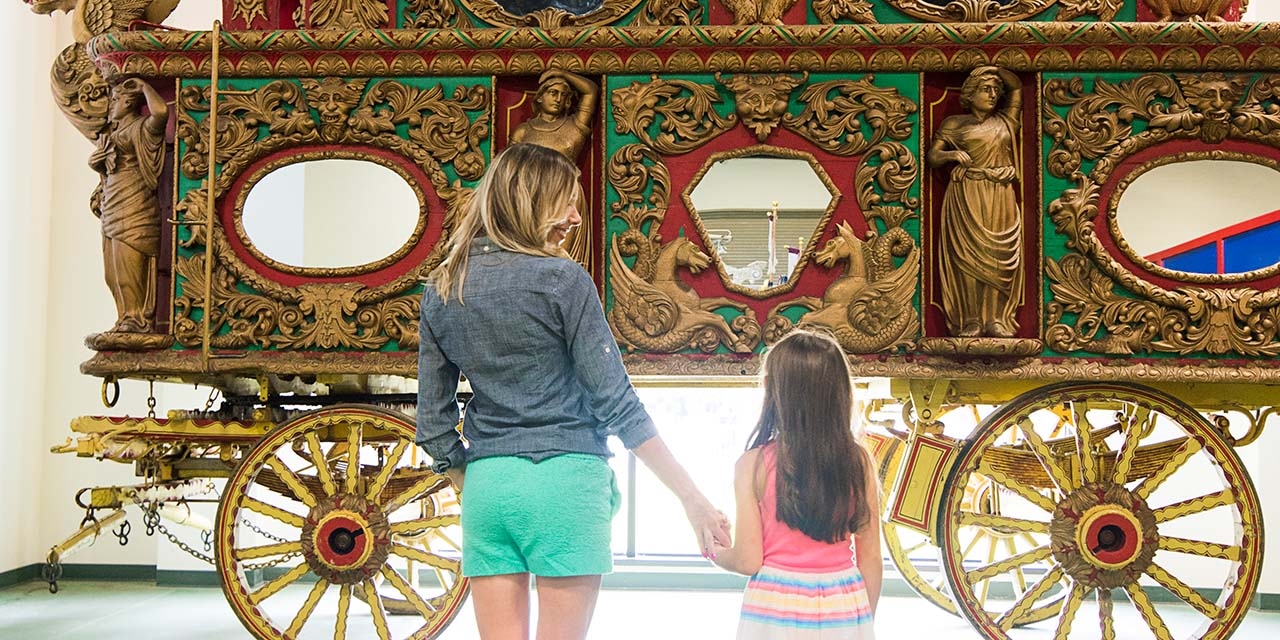 Mother and daughter looking at old circus world wagon