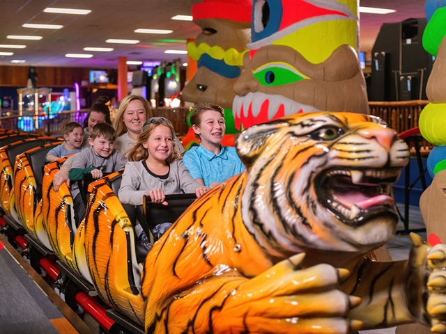 Family riding tiger themed rollercoaster at Knuckleheads.