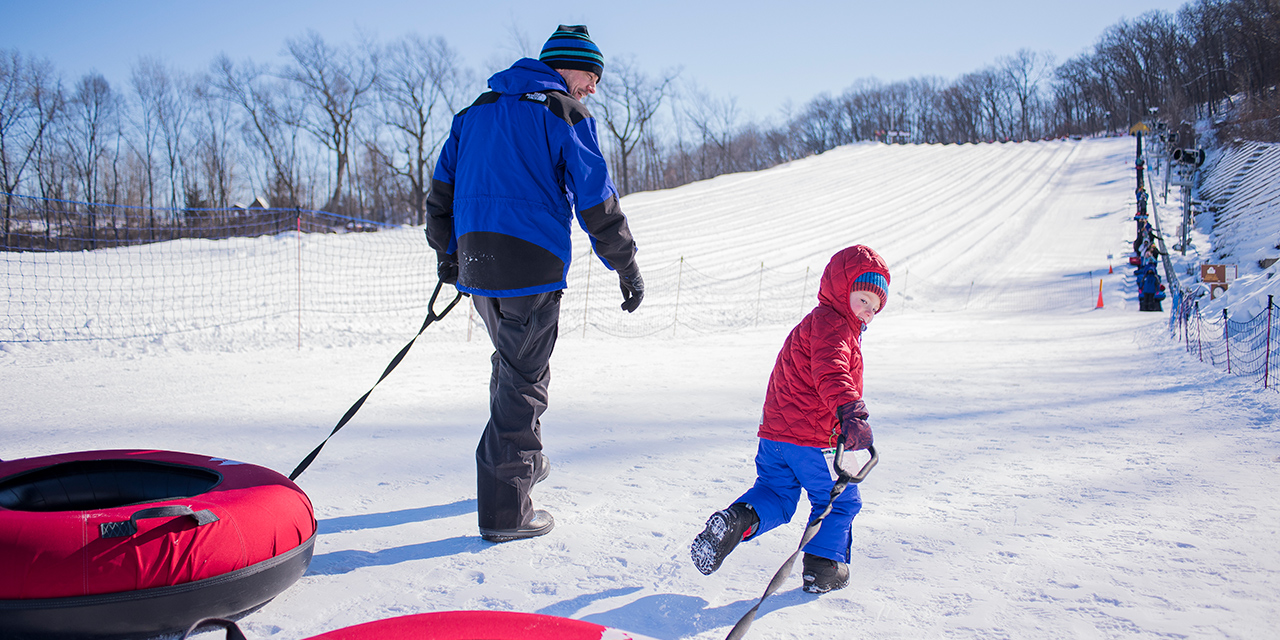 Father and son pulling snow tubes at Cascade Mountain.