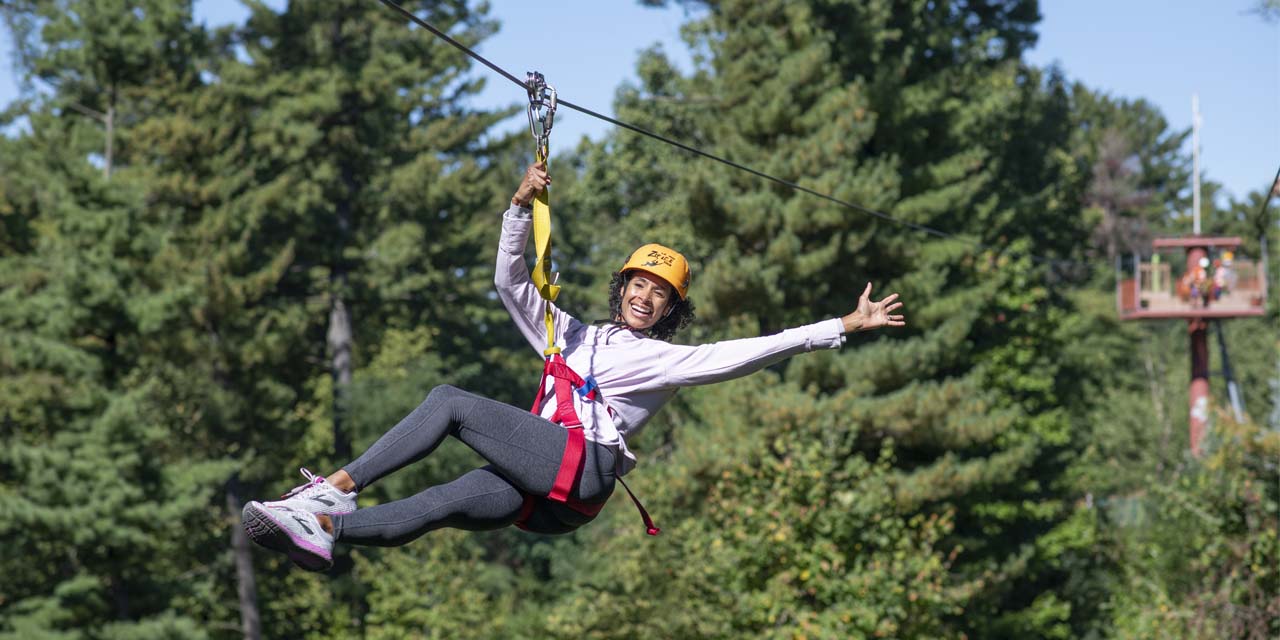 Woman riding a zipline at Wilderness Canyon Zipline Adventure.