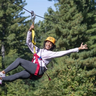 Woman riding a zipline at Wilderness Canyon Zipline Adventure.