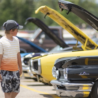 Young man looking at an old classic car.