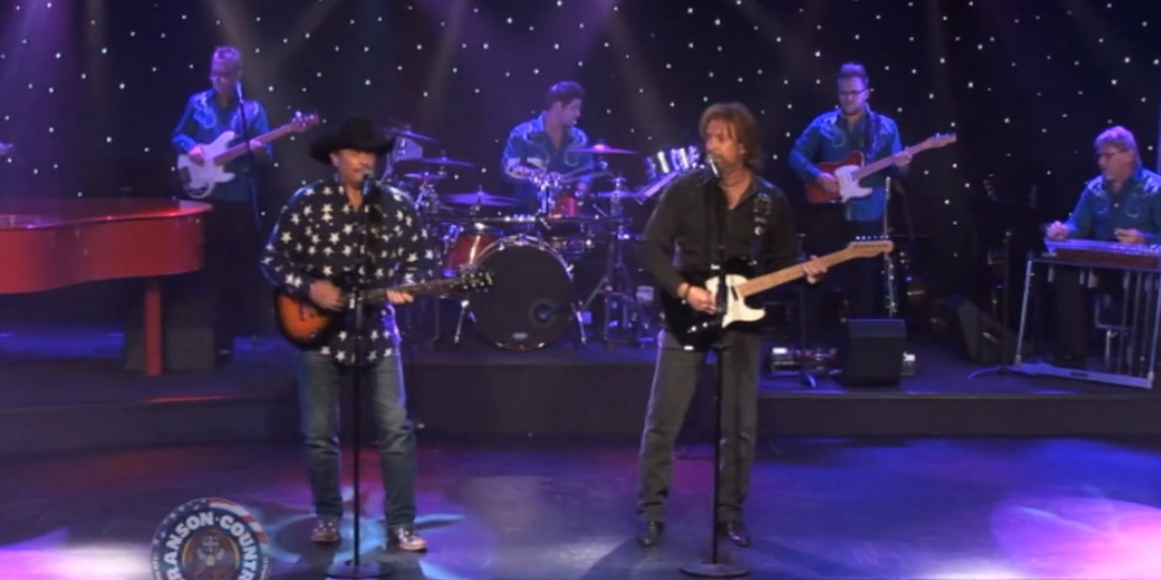 Two guys singing on stage.