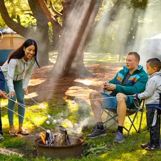 A family sits around a fire pit roasting marshmallows in Wisconsin Dells