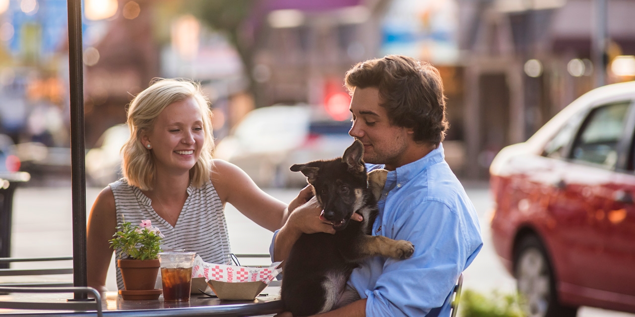 Couple with a puppy in downtown Wisconsin Dells.