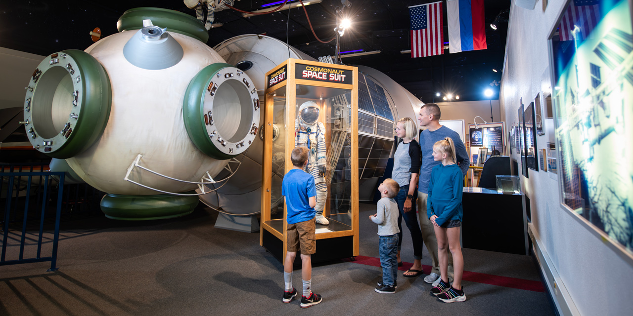 Family looking at a space exhibition at Tommy Bartlett Exploratory.