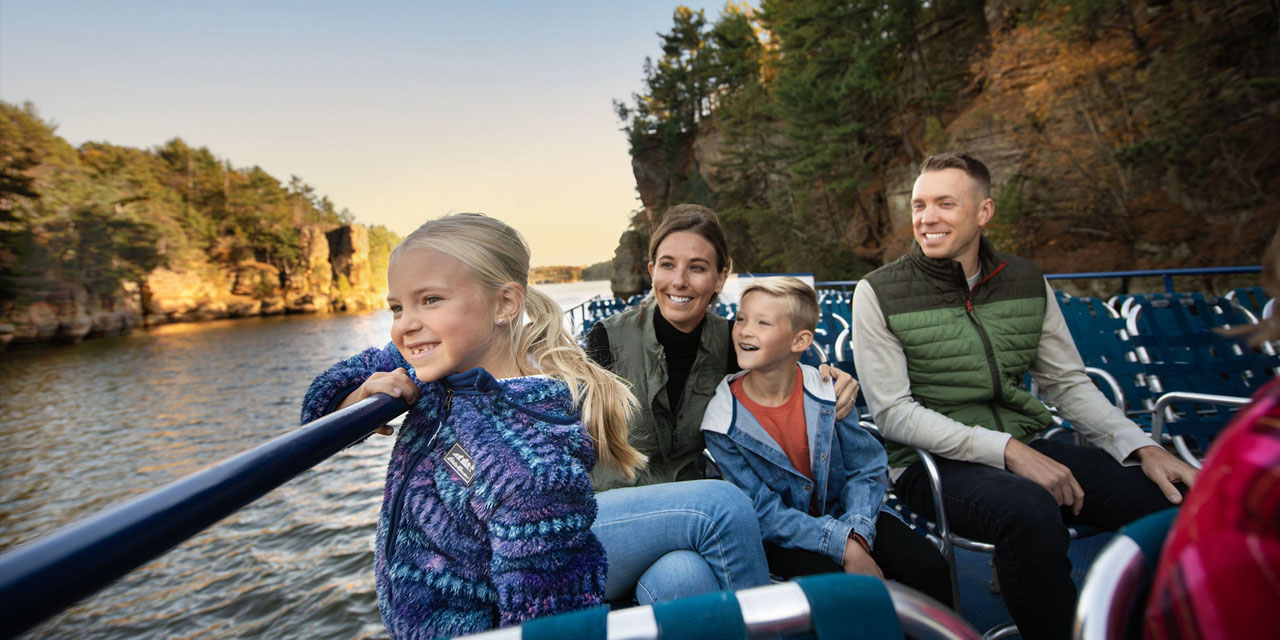 Family on Dells Boat Tours watching fall colors.
