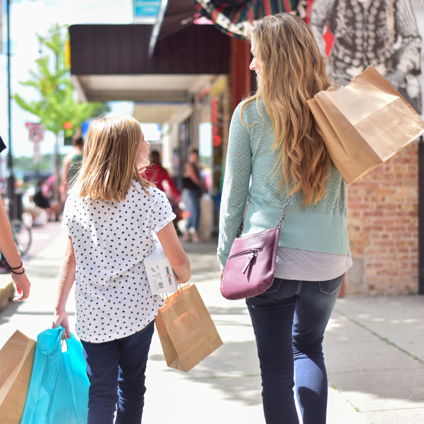 Three people walking in Downtown Wisconsin Dells with shopping bags.