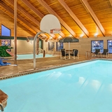 Indoor pool area with basketball hoop, poolside seating, and young-child water area.
