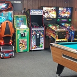 Indoor arcade and game room with pool table and pinball.