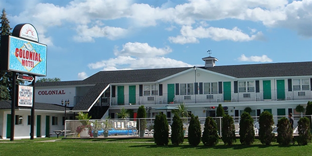 Exterior of Colonial Motel with an outdoor pool area.