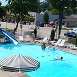 People playing in the outdoor pool area with slides and poolside seating.