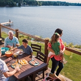 A family enjoying a meal on a waterfront patio.