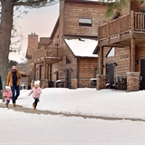 A family walks along the villas in winter.