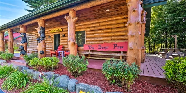 Cabin exterior with benches and bear decorations.
