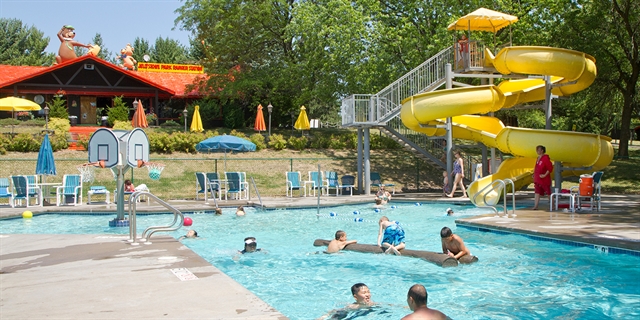 People play at the outdoor pool and waterslide.