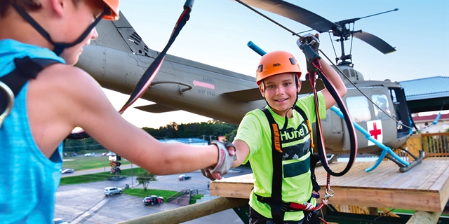 Boy climbing in front of a helicopter.