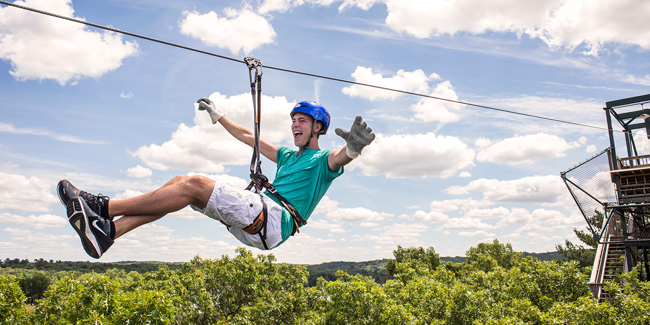 A person zips across Wisconsin Dells on a zipline.