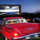 People watch a movie at the drive-in theater.