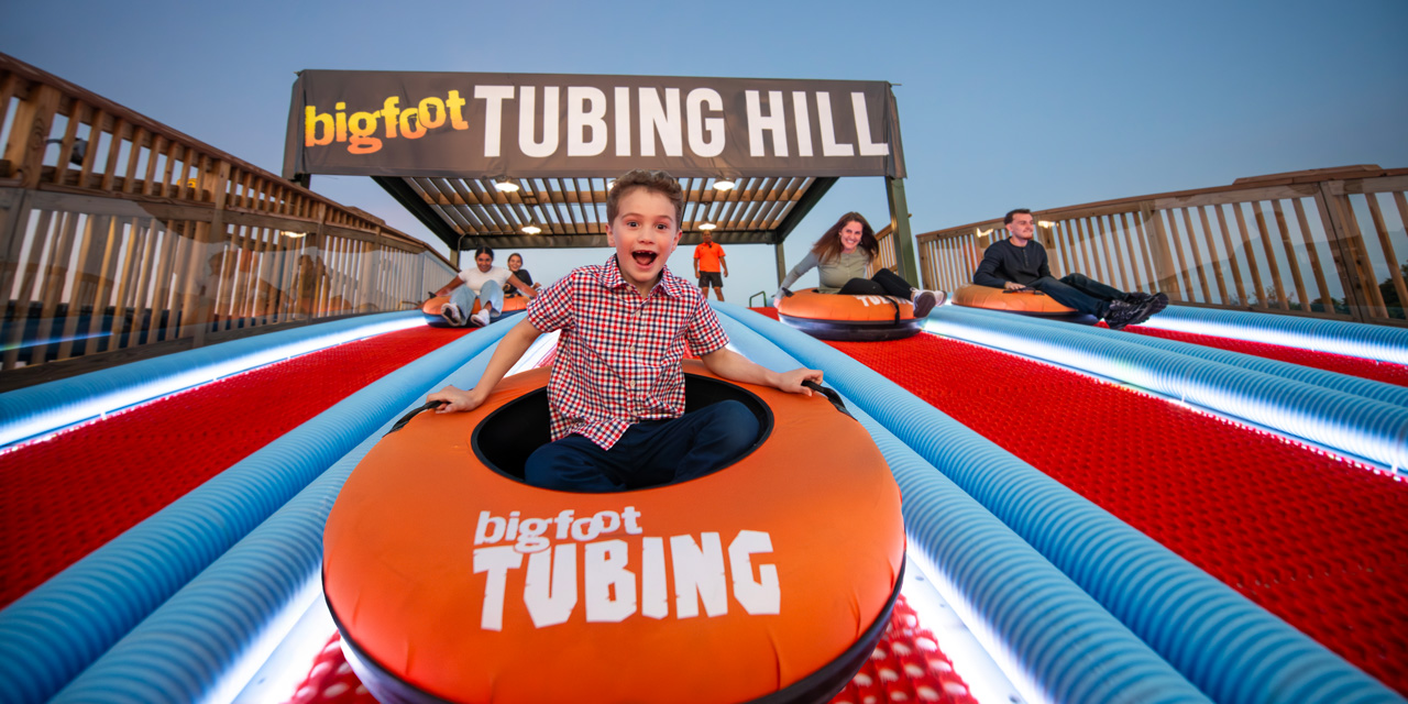 Group of people taking off a tubing hill.