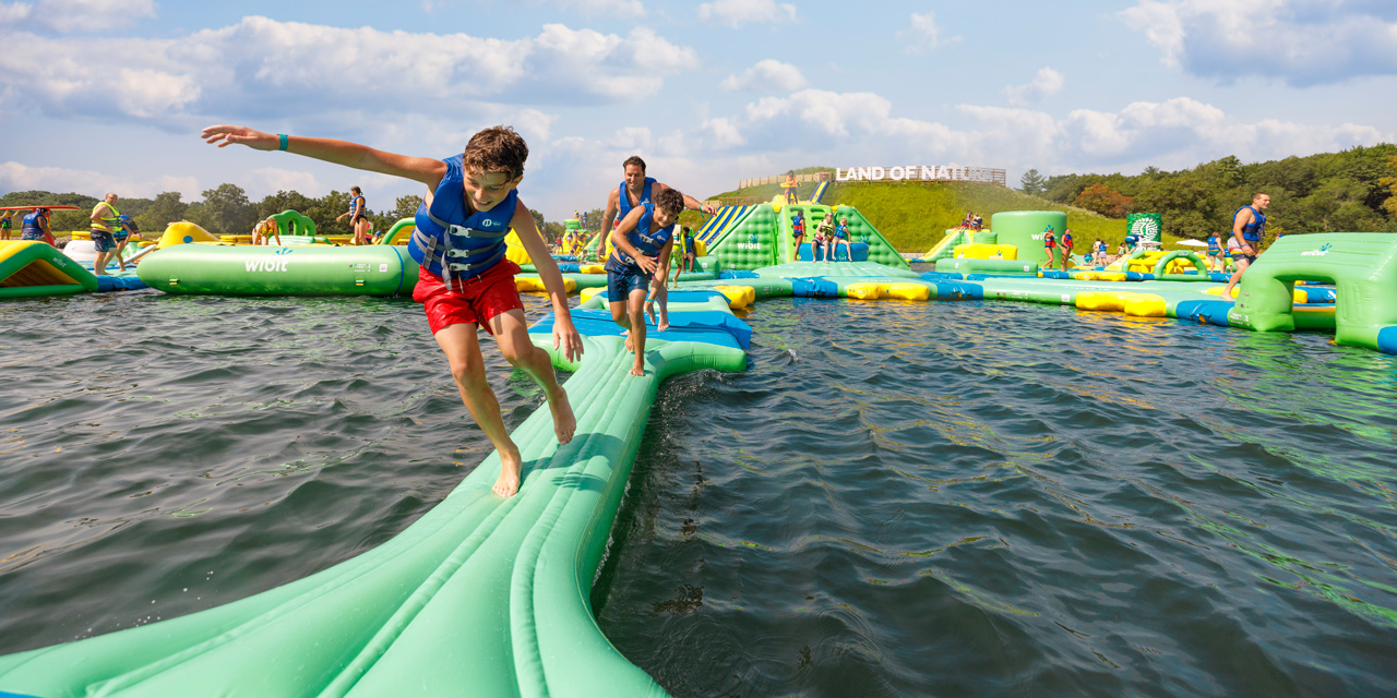 A family having fun on inflatable waterpark at Land of Natura.