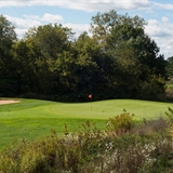 The green at Cold Water Canyon Golf Course surrounded by rich forest.