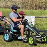 A father and son ride an off-road go-cart.
