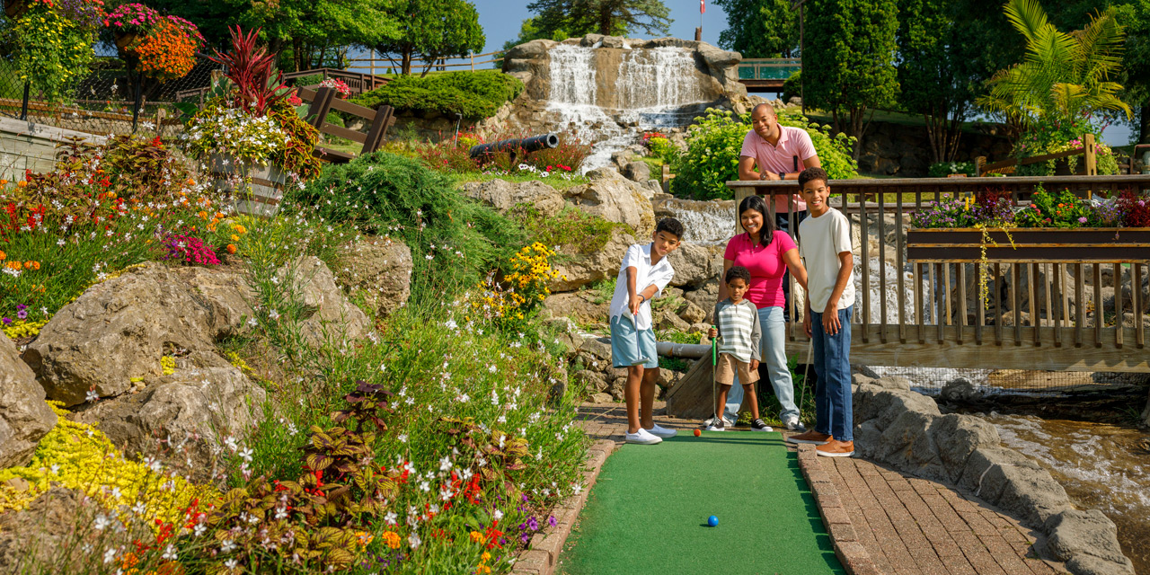 Family playing mini-golf in a gorgeous landscape setting.
