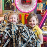 Kids carrying arcade tickets.