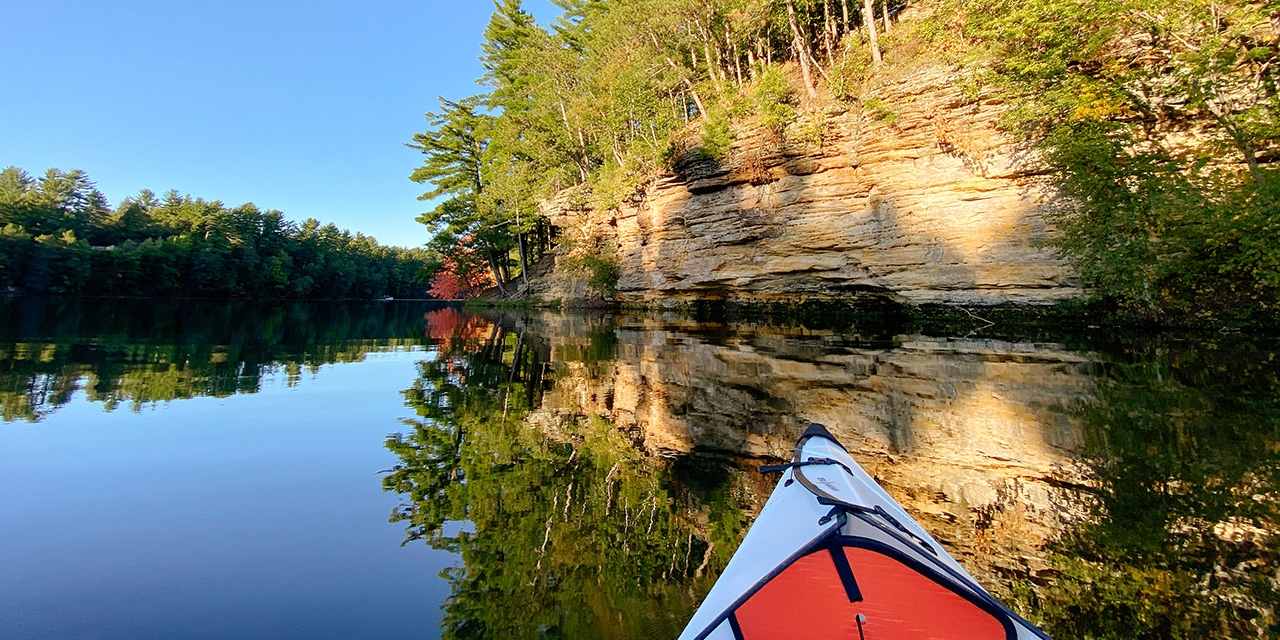 A person kayaks on Mirror Lake.