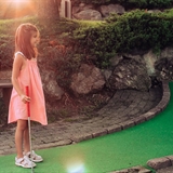 A girl gets ready to start a new hole of mini-golf.