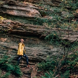 A woman walks along a large rock formation at Rocky Arbor State Park.