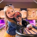A girl holding a mini-bowling ball.