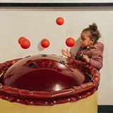 A girl playing with an interactive science exhibit.