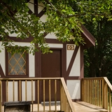 Tudor style lodging with nearby tent-camping area and woods.