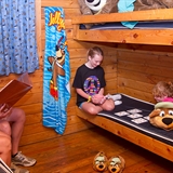 A family spends time in the cabin lodging bedroom.
