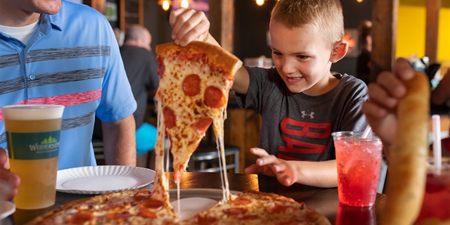 Boy eating pizza at Klondike restaurant at Wilderness.
