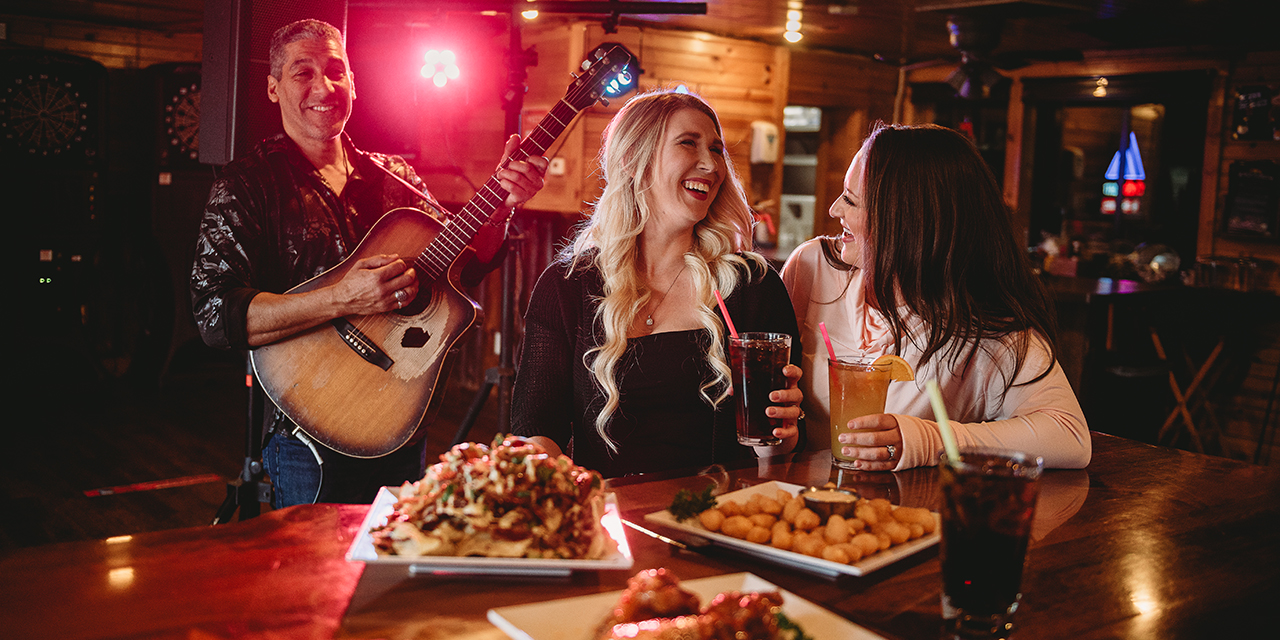 Girls enjoying food while listening to live music.