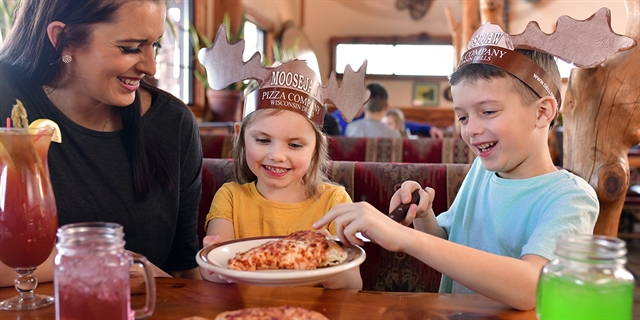 A family grabbing slices of pizza at Moosejaw Pizza & Dells Brewing Co.